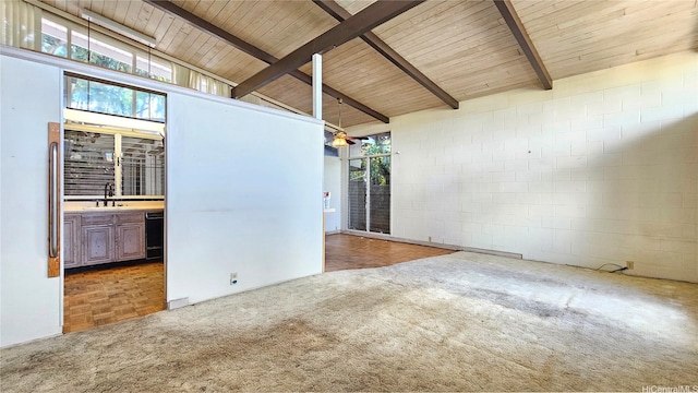 empty room featuring a healthy amount of sunlight, concrete block wall, wooden ceiling, and carpet floors