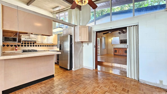 kitchen with ceiling fan, backsplash, appliances with stainless steel finishes, beamed ceiling, and under cabinet range hood