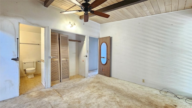 unfurnished bedroom featuring a closet, connected bathroom, wood ceiling, and carpet