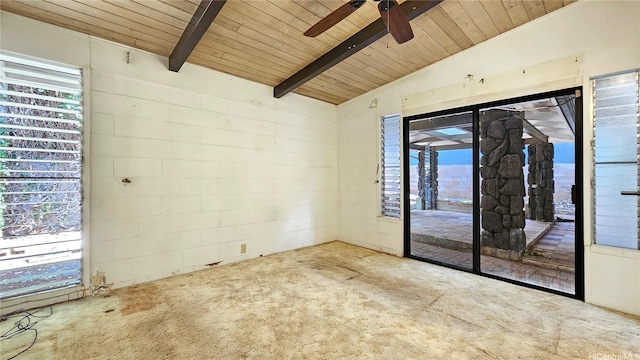 spare room featuring ceiling fan, lofted ceiling with beams, carpet floors, concrete block wall, and wooden ceiling