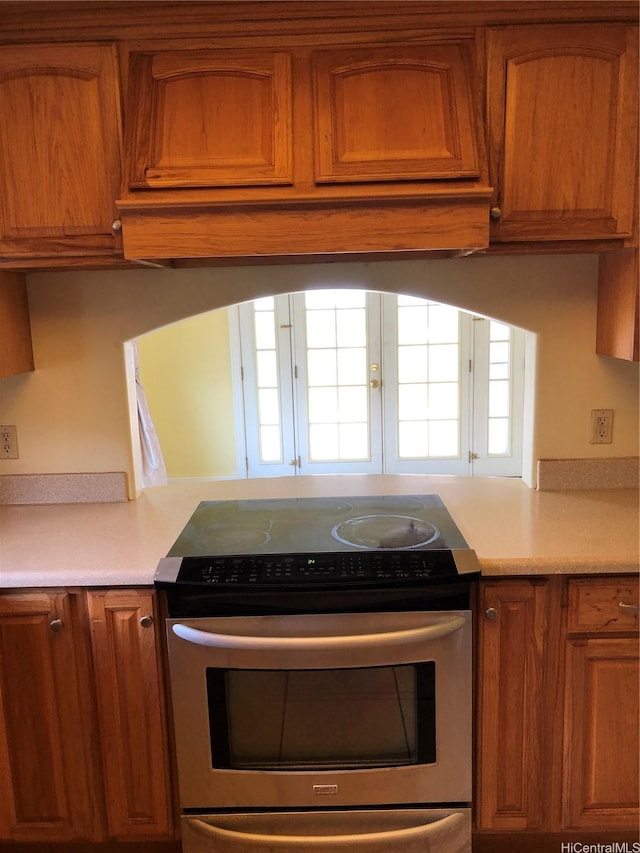 kitchen with brown cabinets, stainless steel range with electric cooktop, and light countertops