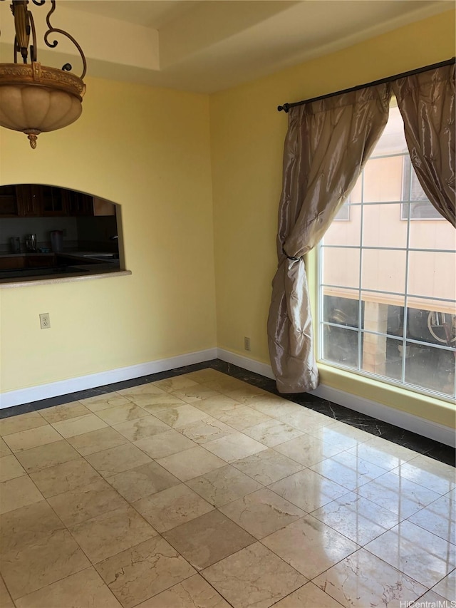 unfurnished room with baseboards
