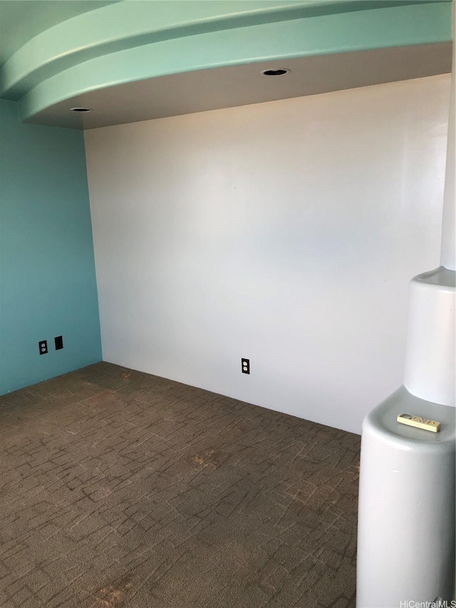 unfurnished room featuring dark colored carpet