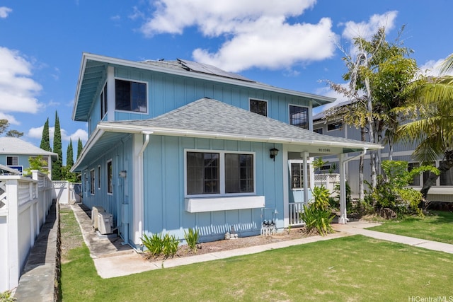 91-1046 Apaa St, Ewa Beach, HI 96706 - view of front of home featuring board and batten siding, a front yard, fence, roof mounted solar panels, and a shingled roof