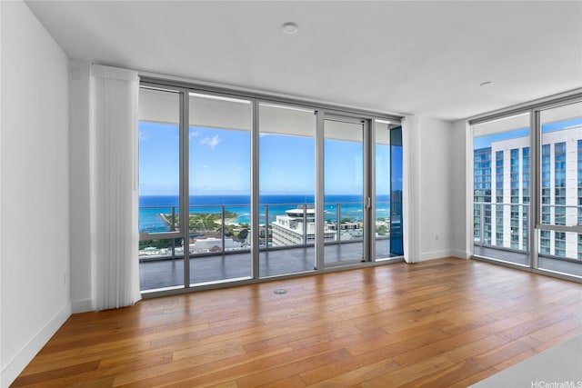629 Keeaumoku St Unit 3401, Honolulu, HI 96814 - unfurnished room featuring wood-type flooring, a water view, and a wall of windows