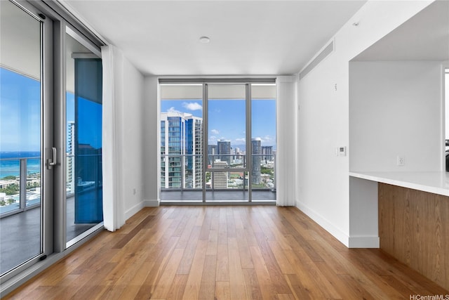 629 Keeaumoku St Unit 3401, Honolulu, HI 96814 - unfurnished room featuring a view of city, plenty of natural light, wood-type flooring, and expansive windows