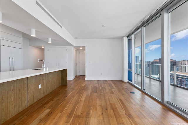 629 Keeaumoku St Unit 3401, Honolulu, HI 96814 - unfurnished living room featuring floor to ceiling windows, a sink, and light wood finished floors