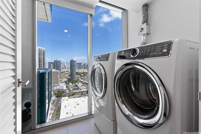 629 Keeaumoku St Unit 3401, Honolulu, HI 96814 - clothes washing area with tile patterned flooring, laundry area, a city view, and washer and dryer