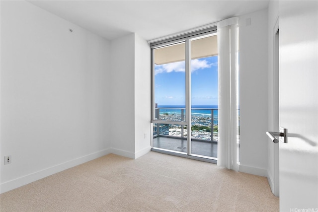 629 Keeaumoku St Unit 3401, Honolulu, HI 96814 - spare room with baseboards, carpet flooring, a water view, and a wall of windows
