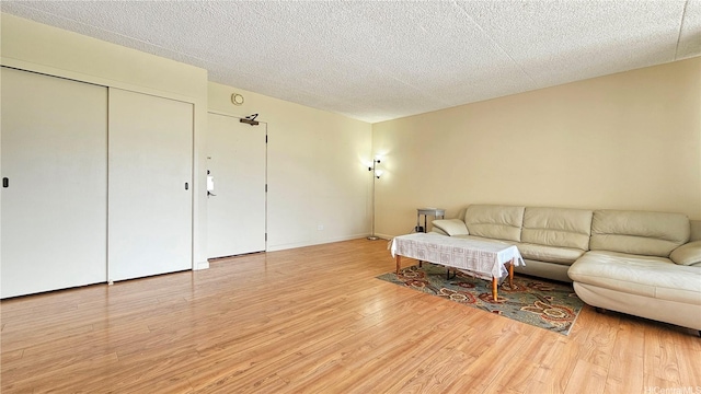 living area with light wood-style floors and a textured ceiling