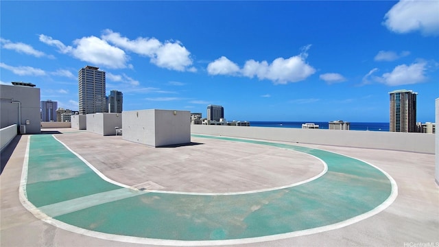 view of basketball court featuring a water view and a city view