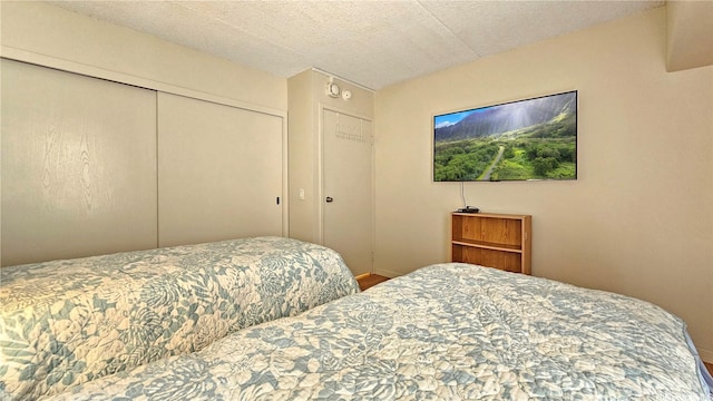 bedroom with a closet, wood finished floors, and baseboards