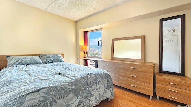 bedroom with light wood finished floors and a textured ceiling