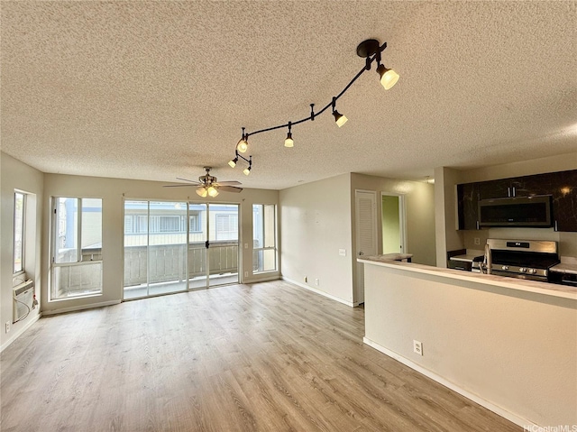 91-291 Hanapouli Cir Unit 4G, Ewa Beach, HI 96706 - unfurnished living room featuring baseboards, a textured ceiling, ceiling fan, and wood finished floors