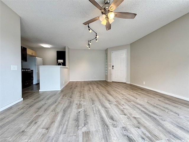 91-291 Hanapouli Cir Unit 4G, Ewa Beach, HI 96706 - unfurnished living room featuring baseboards, a textured ceiling, ceiling fan, and light wood finished floors