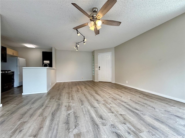 91-291 Hanapouli Cir Unit 4G, Ewa Beach, HI 96706 - unfurnished living room with baseboards, a ceiling fan, a textured ceiling, and wood finished floors