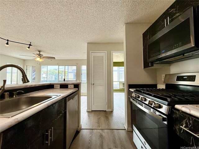 91-291 Hanapouli Cir Unit 4G, Ewa Beach, HI 96706 - kitchen featuring ceiling fan, a textured ceiling, appliances with stainless steel finishes, a sink, and light wood-style floors