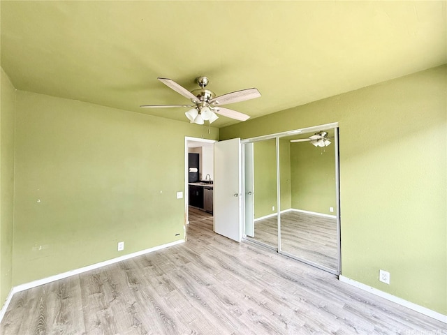 91-291 Hanapouli Cir Unit 4G, Ewa Beach, HI 96706 - unfurnished bedroom with a closet, a ceiling fan, wood finished floors, baseboards, and a sink