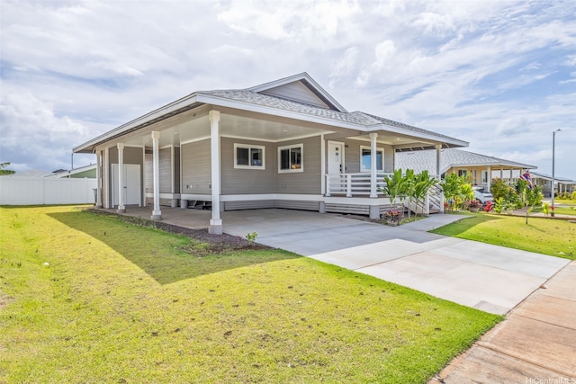 farmhouse inspired home with concrete driveway, a porch, a front yard, and a carport
