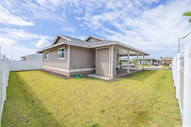 rear view of house featuring a yard, roof with shingles, and fence private yard