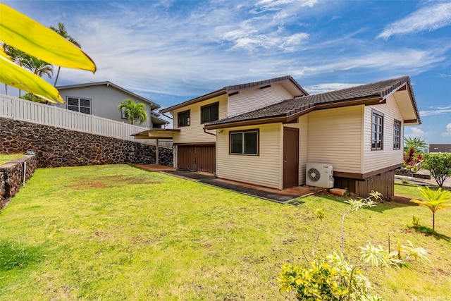rear view of property featuring a lawn, fence, and ac unit