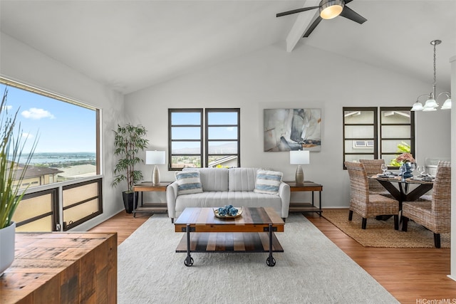 living area with lofted ceiling with beams, wood finished floors, and ceiling fan with notable chandelier