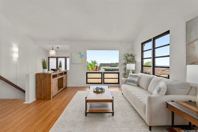 living area with light wood-style flooring and lofted ceiling