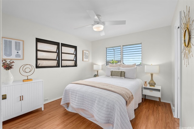 bedroom featuring baseboards, a ceiling fan, and wood finished floors