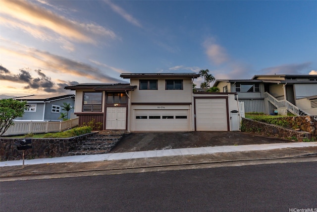 view of front of property featuring an attached garage, solar panels, and aphalt driveway