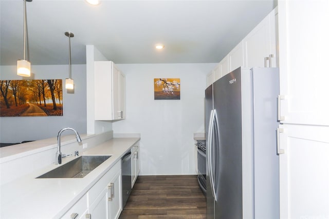 kitchen featuring dark wood finished floors, a sink, light countertops, stainless steel appliances, and white cabinetry