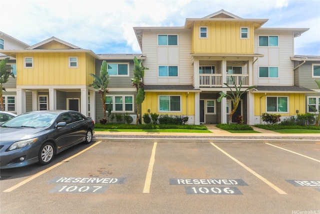 townhome / multi-family property with board and batten siding and uncovered parking