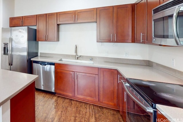 kitchen with light countertops, stainless steel appliances, dark wood-type flooring, and a sink