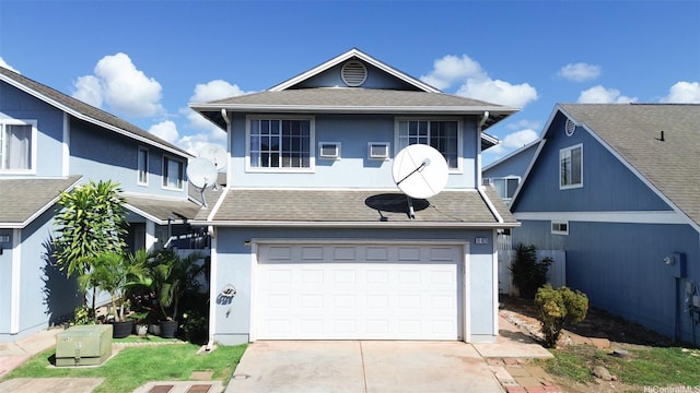 traditional-style home with roof with shingles, an attached garage, concrete driveway, and stucco siding