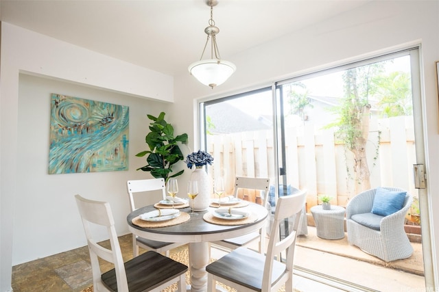 dining space featuring a healthy amount of sunlight and stone finish floor