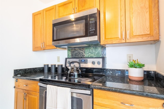 kitchen with dark stone counters and stainless steel appliances