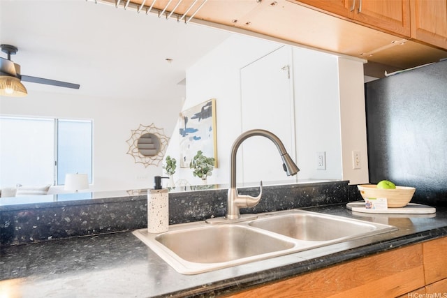 room details featuring a sink, ceiling fan, and dark countertops