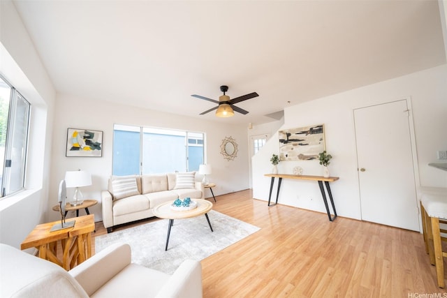 living area with a ceiling fan and light wood-style flooring