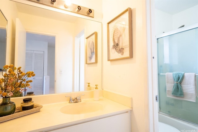 full bath featuring vanity, enclosed tub / shower combo, and toilet