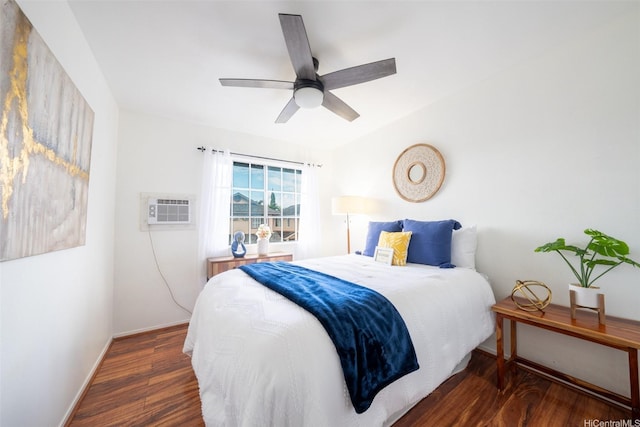 bedroom with baseboards, ceiling fan, a wall unit AC, and wood finished floors