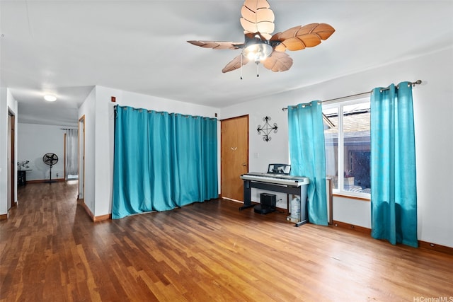 interior space featuring a ceiling fan, baseboards, and wood finished floors