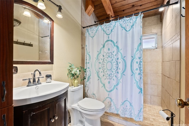 bathroom with vanity, a textured wall, a shower with curtain, and toilet