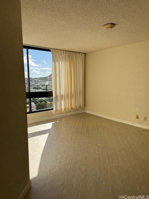 carpeted empty room featuring baseboards and a textured ceiling