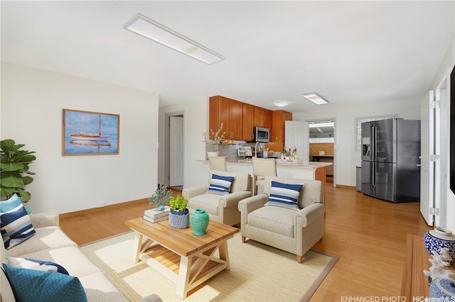 living room featuring light wood-style floors and baseboards