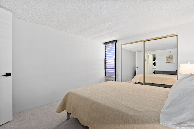 carpeted bedroom with a closet and a textured ceiling