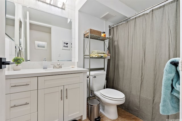 bathroom with toilet, vanity, and curtained shower