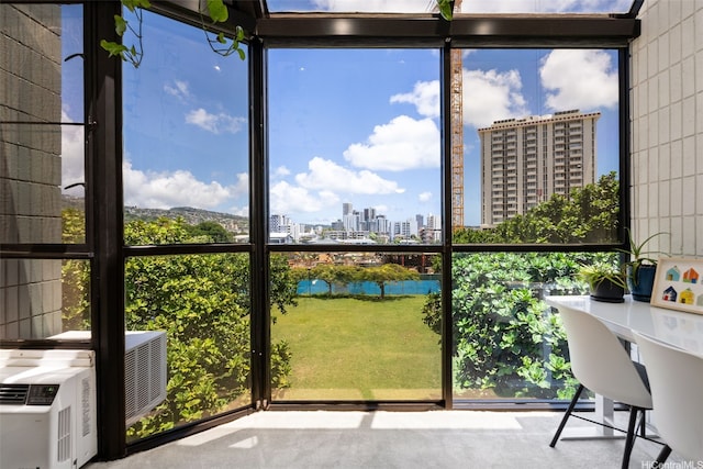 unfurnished sunroom featuring a water view and a city view