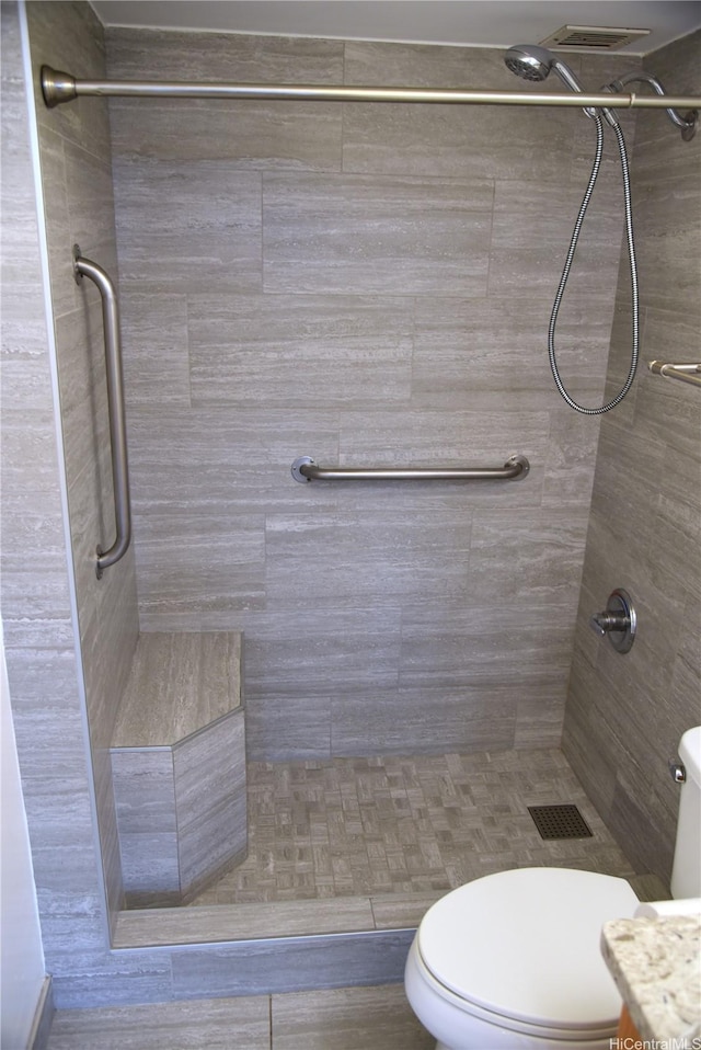 full bath featuring toilet and tiled shower