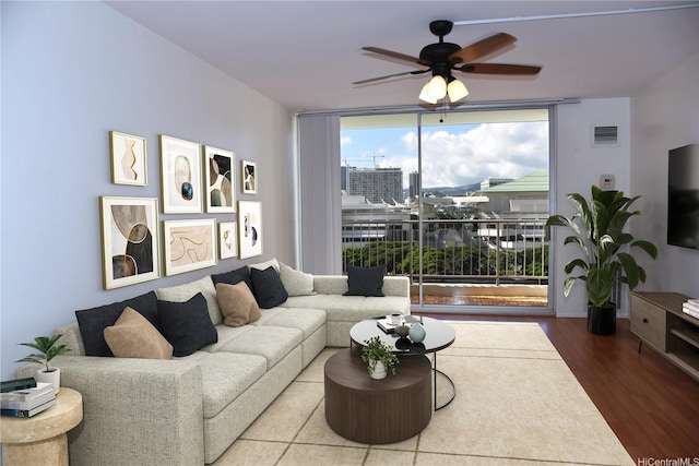 living room featuring visible vents, ceiling fan, expansive windows, and wood finished floors