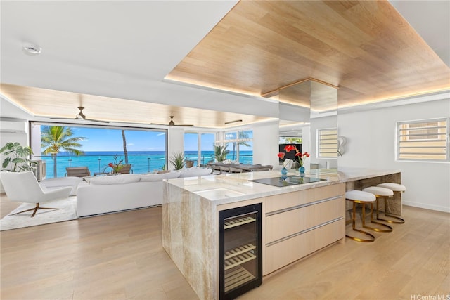 kitchen featuring beverage cooler, light wood-style floors, wooden ceiling, and black electric cooktop