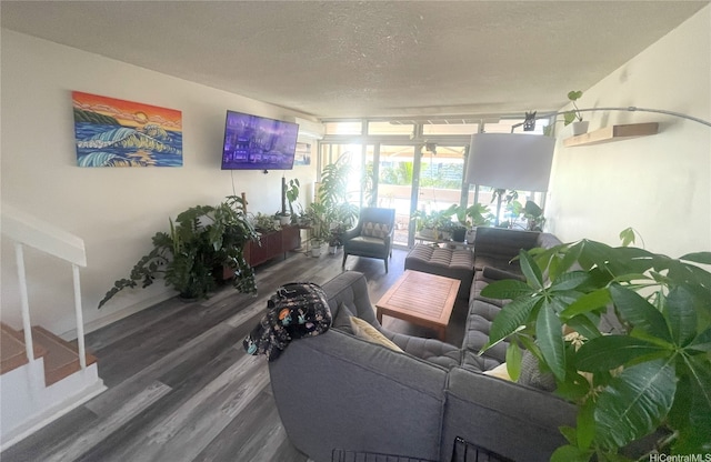 living room with baseboards, a textured ceiling, and wood finished floors